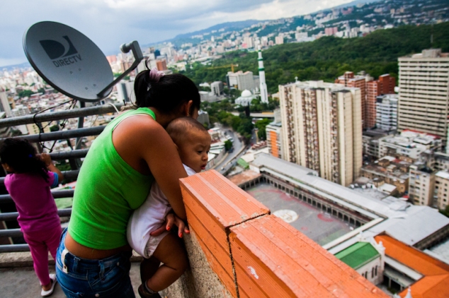 Una mujer asoma su bebé por la terraza desde el piso 27 de la Torre de David